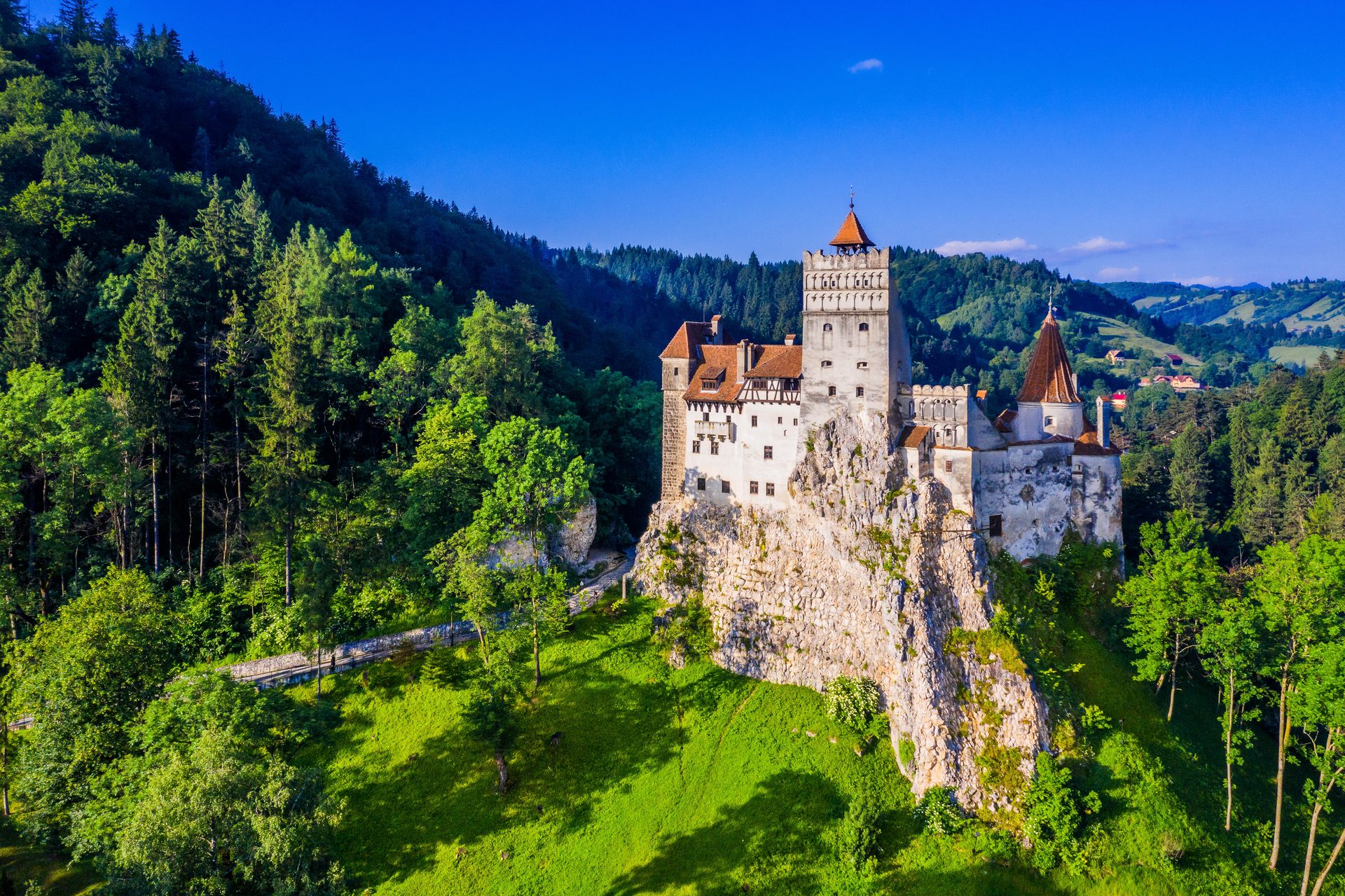 Bran Castle in summer with crowds of visitors below the castle entrance