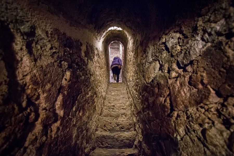 The secret staircase hidden inside the castle well at Bran Castle — narrow stone steps spiralling between floors