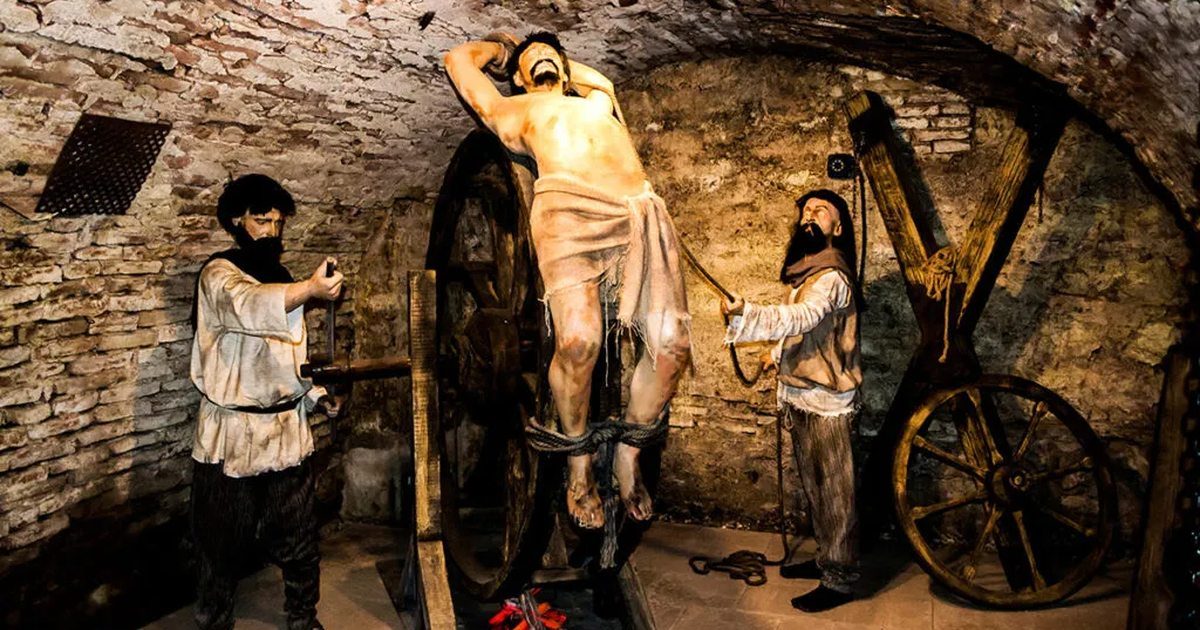 Medieval torture chamber wax figures in the vaulted stone dungeon at Bran Castle