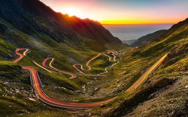 Transfăgărășan Highway at sunset with light trails winding through the Carpathian Mountains