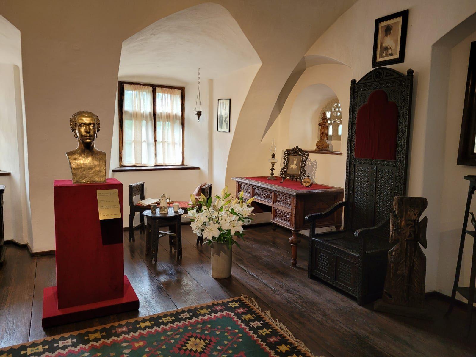 Queen Marie's royal apartments inside Bran Castle — furnished rooms with carved wooden furniture and tapestries